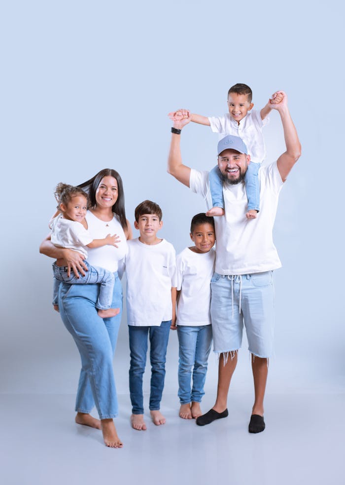 Cheerful family of six posing together in casual outfits, showcasing unity and happiness.