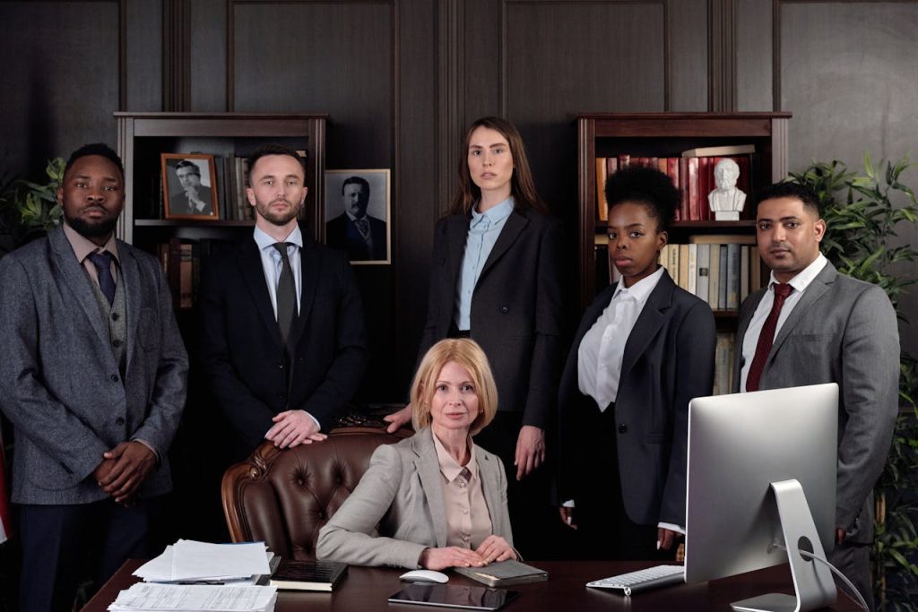 lawyers-posing-for-a-photo-4427430 Diverse group of professionals in corporate attire posing confidently in an office environment.
